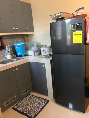 een keuken met een zwarte koelkast en een keukenkleed bij 2-Storey Rental Unit w/ Garage in Balanga Bataan in Tinajero