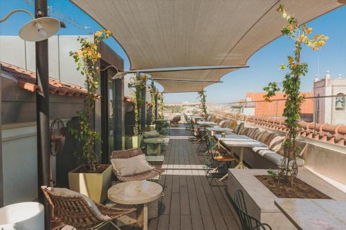 a patio area with tables, chairs and umbrellas at The Lumiares Hotel & Spa - Small Luxury Hotels Of The World in Lisbon