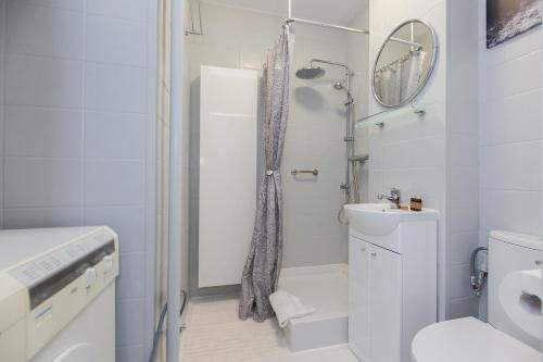 a white bathroom with a shower and a toilet at ShortStayPoland Chłodna (B74) in Warsaw