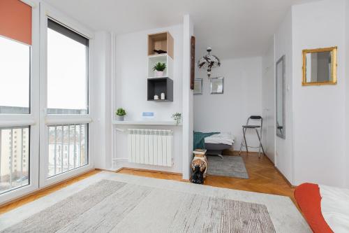 a living room with white walls and large windows at ShortStayPoland Chłodna (B74) in Warsaw