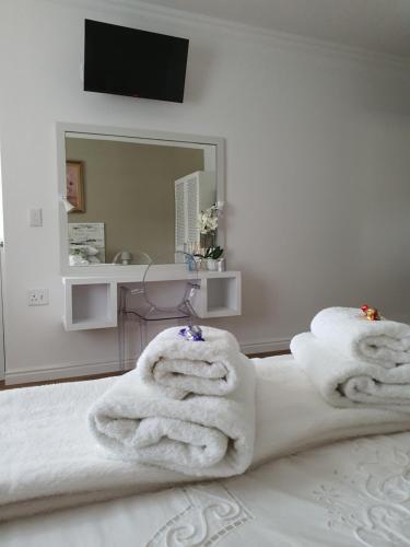 a bedroom with white towels on a bed at Plett57 - Self Catering - Room No2 in Plettenberg Bay