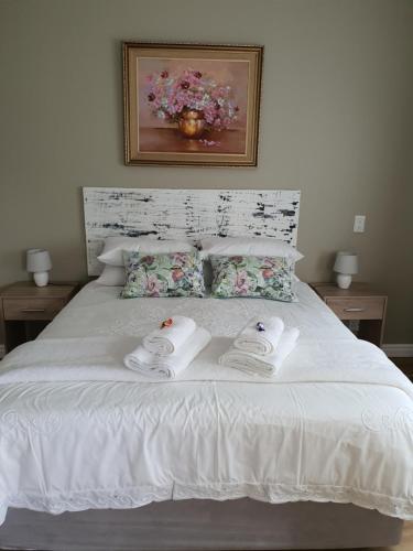 a bedroom with a white bed with towels on it at Plett57 - Self Catering - Room No2 in Plettenberg Bay