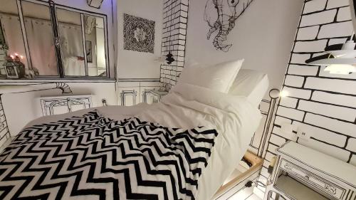 Dormitorio blanco con cama blanca y negra en Studio illustré Insolite en Sablé-sur-Sarthe