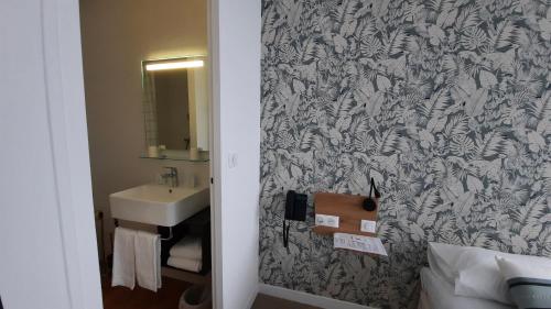 uma casa de banho com um lavatório e um espelho em Au Bon Accueil em Perros-Guirec