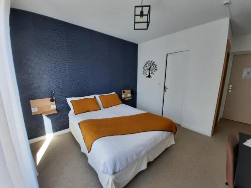 a bedroom with a large bed with orange pillows at Au Bon Accueil in Perros-Guirec