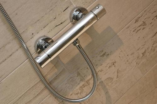 a shower head with a hose on a wooden floor at Holiday home with Estuary Views, parking & balcony in Padstow