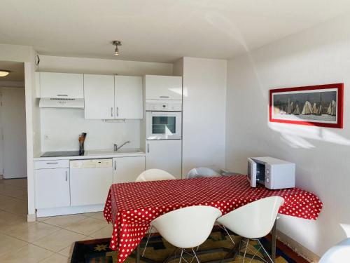 une cuisine avec une table avec une nappe rouge et blanche dans l'établissement HORTENSIAS - Rez-de-jardin, Vue Mer, Plage - T6, à Carnac
