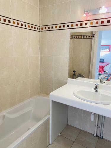 une salle de bain avec une baignoire blanche et un lavabo dans l'établissement HORTENSIAS - Rez-de-jardin, Vue Mer, Plage - T6, à Carnac