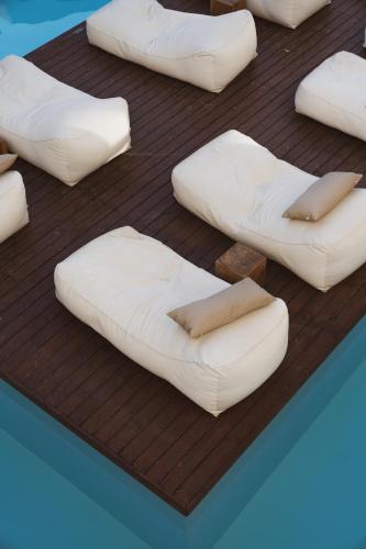 a group of white pillows on a wooden deck at Cavo Vezal in Laganas