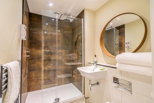 a bathroom with a shower and a sink and a mirror at York Staycation with Free Parking in York