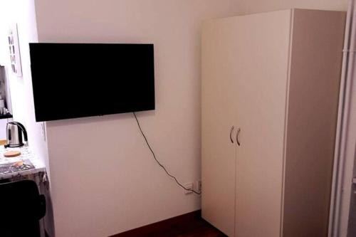 a flat screen tv on a wall next to a cabinet at Elegant Studio fully furnished apartment! @Zürich 4 in Zurich
