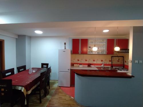a kitchen with red cabinets and a white refrigerator at Ivan Apartment Skopje in Skopje
