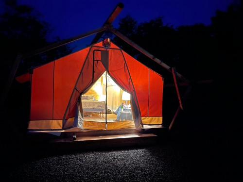 a small tent is lit up at night at Naturluxe & Stars in Watkins Glen