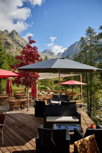 une terrasse avec des chaises, un parasol et des tables dans l'établissement Relais des Merveilles, à Belvédère