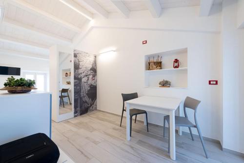 a white dining room with a white table and chairs at La Retara Affittacamere in San Benedetto del Tronto