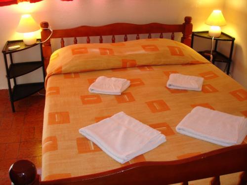 a wooden bed with two towels on top of it at Alizes Bungalows in Sainte-Anne