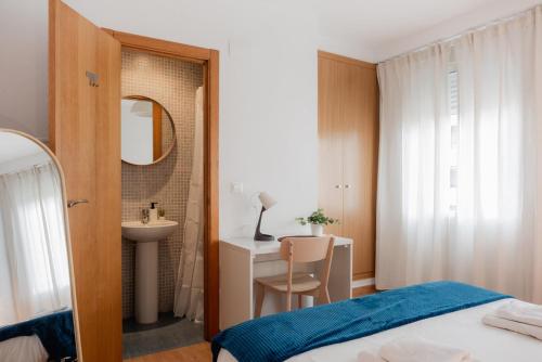 a bedroom with a bed and a sink and a mirror at Apartamentos FV Flats Valencia - Mestalla 5 in Valencia