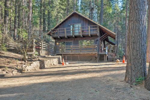a log cabin in the middle of a forest at Walk Downtown Arnold Cabin with Large Deck! in Arnold