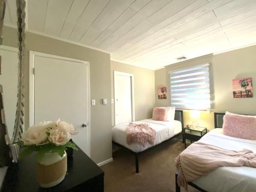 a bedroom with two beds and a table with flowers at A Modern Apt close to downtown in Lancaster