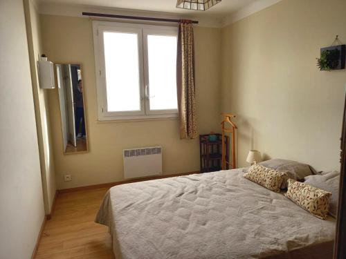 a bedroom with a large bed and a window at Joli appartement face à la mer- Grisgione in San-Martino-di-Lota