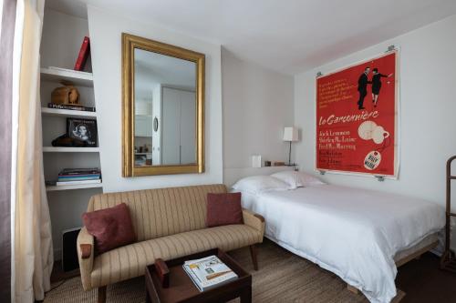 - une chambre avec un lit, un canapé et un miroir dans l'établissement Luxe Atelier bail mobilité Saint germain des Près, à Paris
