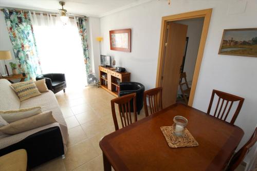 sala de estar con mesa y sofá en Apartament Cala Merced Alicante El Campello, en El Campello