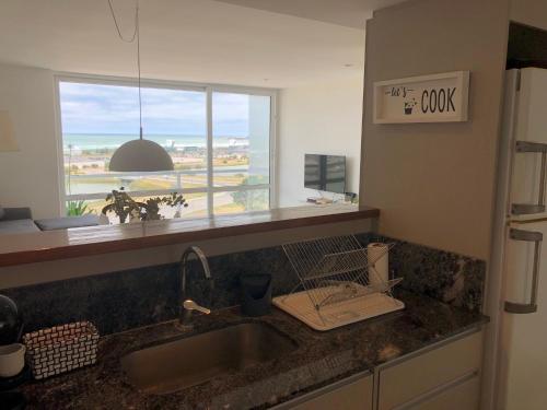 a kitchen counter with a sink and a window at Susurros del Mar, Amplio semi-piso frente al mar in Mar del Plata