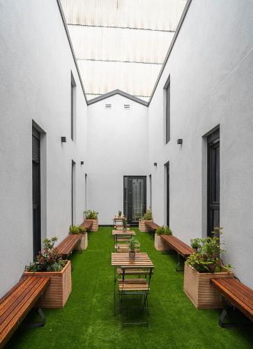a row of tables and benches in a building at Dpaso hostel in Chantada