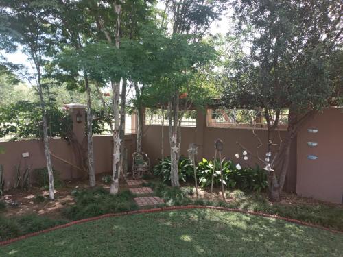 a backyard with a fence and trees at 75 on Milner Lodge in Kimberley