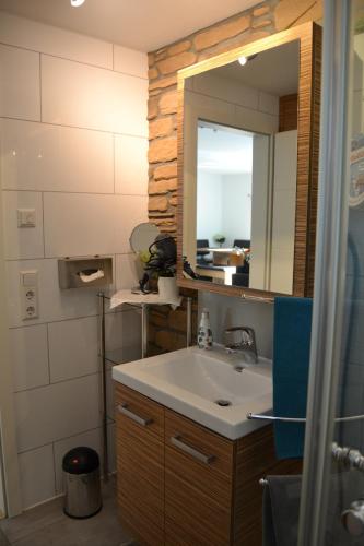 La salle de bains est pourvue d'un lavabo et d'un miroir. dans l'établissement Fewo-Burgund, à Billigheim-Ingenheim