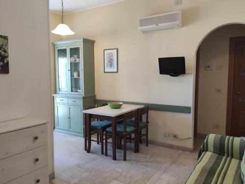 ディアーノ・マリーナにあるAppartamenti Bemarのテーブルと椅子、ベッドルーム1室が備わります。