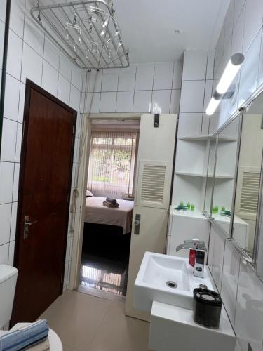 een witte badkamer met een wastafel en een spiegel bij Copacabana Apartamento in Rio de Janeiro