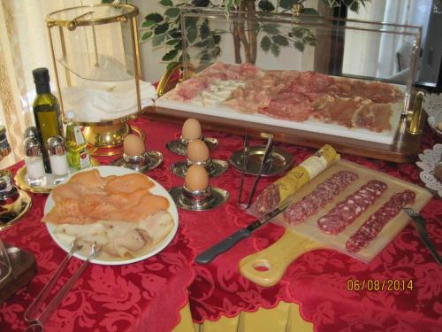 a table topped with meat and eggs on a table at Hotel Matilde in Marina di Massa