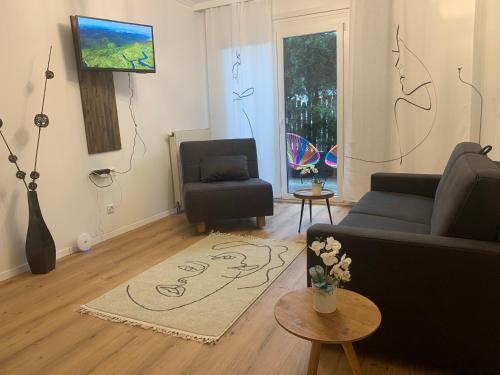 ein Wohnzimmer mit einem Sofa und einem Stuhl in der Unterkunft Exclusive Holiday Apartments in Villach