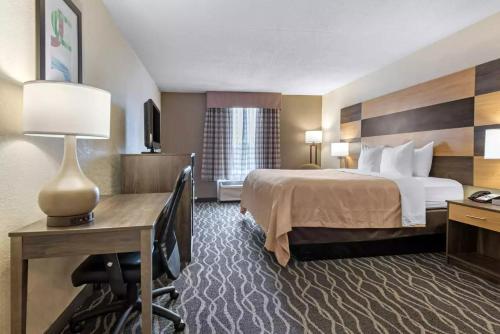 Habitación de hotel con cama y escritorio con lámpara. en Quality Inn & Suites Lafayette I-65, en Lafayette