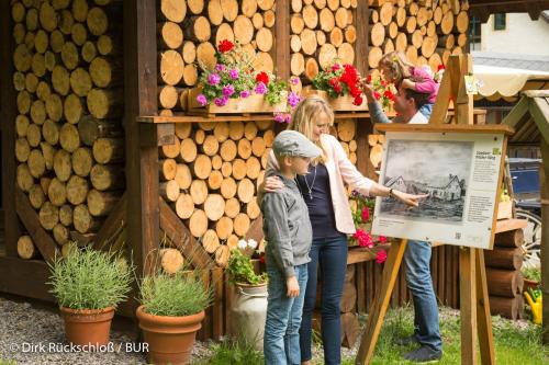 a woman and a child standing in front of a sign at Altsächsischer Gasthof Kleines Vorwerk in Sayda