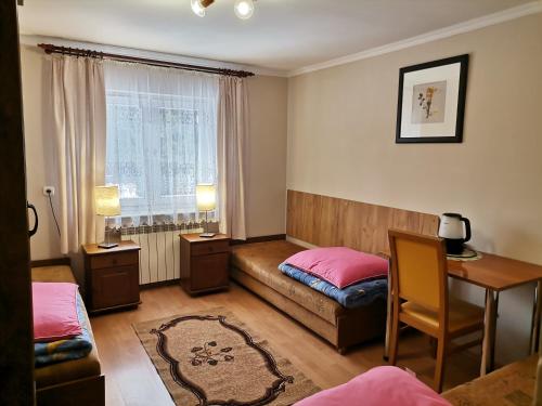 a bedroom with a bed and a desk and a window at Agroturystyka u Marii in Komańcza