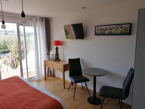 1 dormitorio con escritorio, 1 cama y 1 mesa en Les Terrasses du Ris, en Douarnenez
