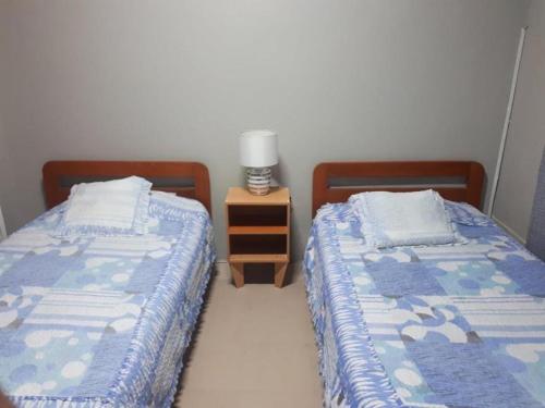 two beds sitting next to each other in a bedroom at Hostal Copa Arica in Arica