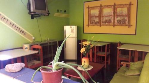 a kitchen with green walls and a white refrigerator at Hostal Copa Arica in Arica