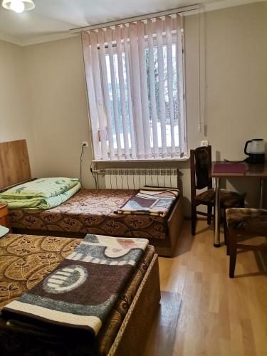 a room with two beds and a desk and a window at Agroturystyka u Marii in Komańcza