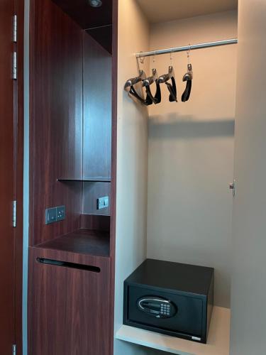 a room with a closet with hangers and a stove at AM Hotel in Singapore