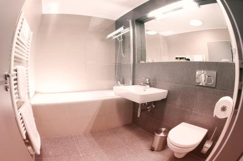 a bathroom with a sink and a tub and a toilet at Villa na Vinici in Prague