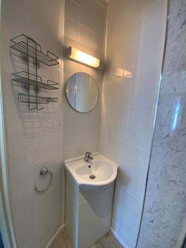 a white bathroom with a sink and a mirror at The Laurels Hotel in Skegness