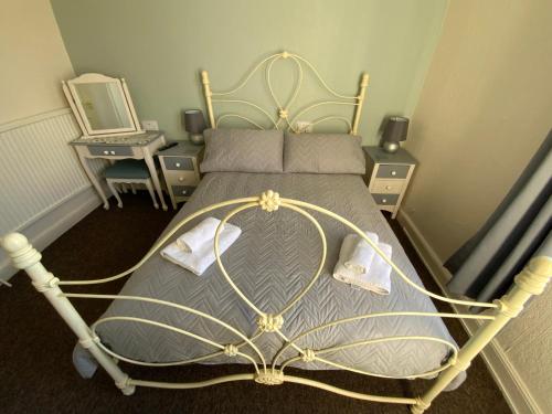 a bed with a metal frame in a bedroom at The Laurels Hotel in Skegness