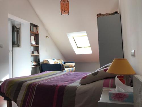 a bedroom with a bed and a lamp on a table at La Coudraie: Loft sauna/jacuzzi privatif à la campagne in Saint-Pardoux-le-Vieux
