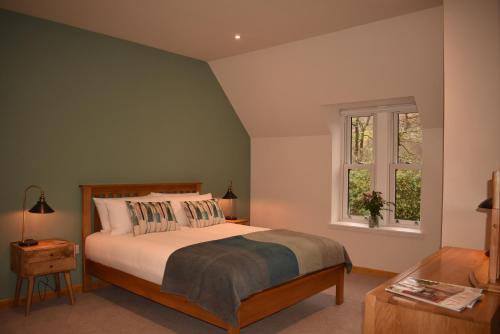 1 dormitorio con cama y ventana en Orchy Bank House en Dalmally