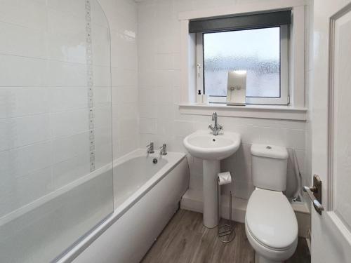 a white bathroom with a toilet and a sink at 3 bedroom house Amazon M90 Dunfermline Edinburgh in Fife