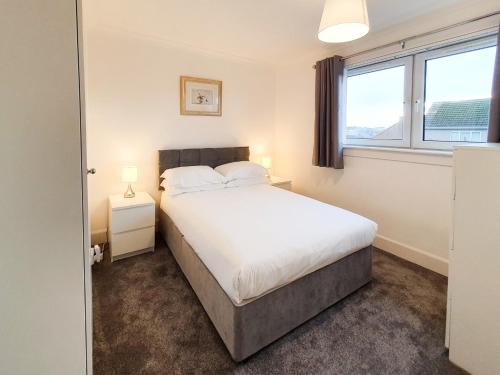 法夫的住宿－3 bedroom house Amazon M90 Dunfermline Edinburgh，一间卧室设有一张床和两个窗户。