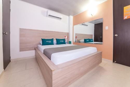 a bedroom with a large bed and a mirror at Ayenda Hospedaje WIV in Cúcuta